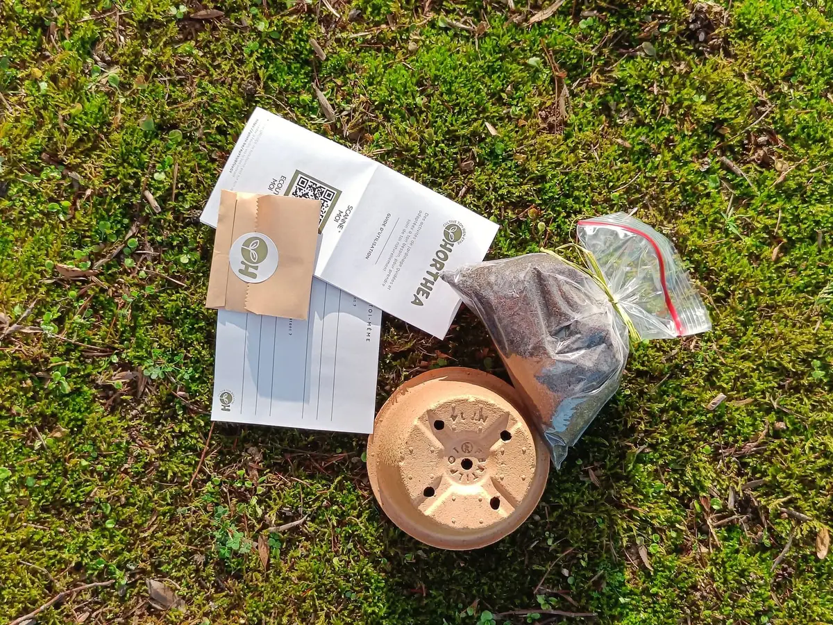 Contenu du kit de jardinage bien-être étalé : pot, terreau, guide papier et graines de capucine
